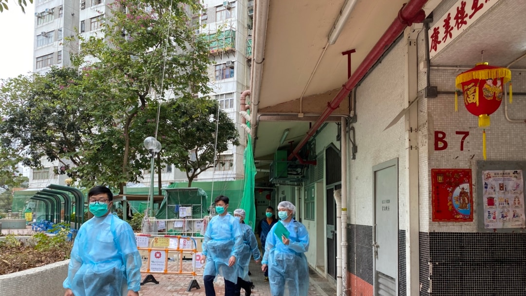 多名穿上保護衣的警員在康美樓出入口查詢出入的住客。(美國之音 湯惠芸拍攝)