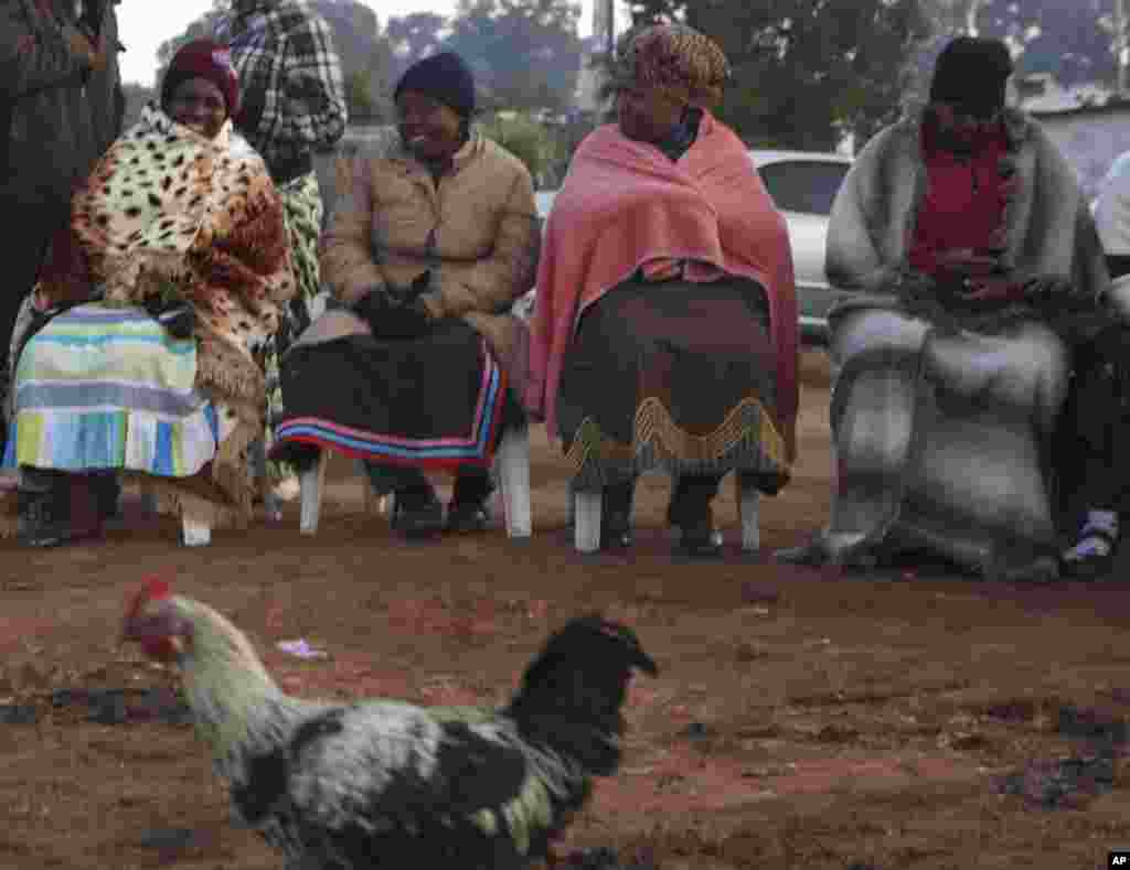 Para perempuan duduk dan mengantre giliran memberikan suara di sebuah pemukiman sementara di Soweto, Afrika Selatan (7/5).&nbsp;(AP/Denis Farrell)