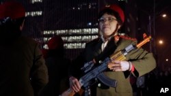 Chinese women wearing military costume march with toy guns during their daily exercises at a square outside a shopping mall in Beijing, March 24, 2015. 