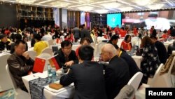 FILE - Local businessmen and foreign investors negotiate at a cross-border investment and trade fair in Guiyang, Guizhou province, China, Nov. 10, 2016. 