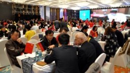 FILE - Local businessmen and foreign investors negotiate at a cross-border investment and trade fair in Guiyang, Guizhou province, China, Nov. 10, 2016. 