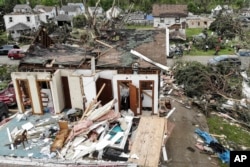 Repair and cleaning efforts begin on a neighborhood damaged by a tornado storm system that passed through the area, destroying homes and cutting off access to utilities, May 29, 2019, in Dayton, Ohio.