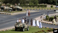 Soldiers keep watch from army armored vehicles at a roundabout after protesters dispersed in the northern industrial town of Sohar in Oman March 1, 2011