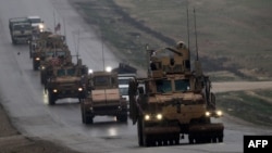 FILE - A convoy of US military vehicles is seen in Syria's northern city of Manbij, Dec. 30, 2018.