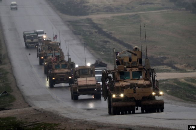 FILE - A convoy of U.S. military vehicles is seen in Syria's northern city of Manbij, Dec. 30, 2018.