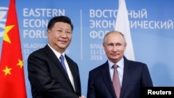 Tổng thống Nga Vladimir Putin bắt tay với Chủ tịch Trung Quốc Tập Cận Bình tại Diễn đàn Kinh tế Đông ở Vladivostok, Nga, ngày 11 tháng 9 năm 2018, cùng thời điểm diễn ra cuộc thao dượt quân sự Vostok-2018 (Đông-2018) của Nga có Trung Quốc tham gia, diễn ra gần biên giới Trung Quốc.