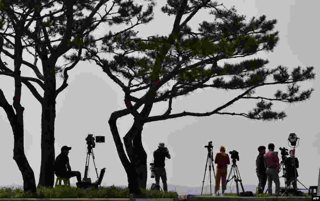 Cameramen record video footage of the North Korean border county of Kaepoong from a South Korean observation post in the border city of Paju.