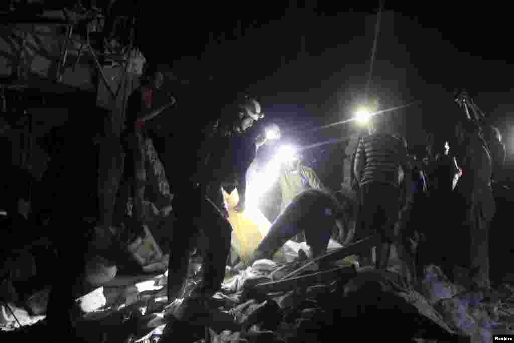Civil defense members search for survivors after an airstrike at a field hospital in the rebel held area of al-Sukari district of Aleppo, Syria, April 27, 2016.
