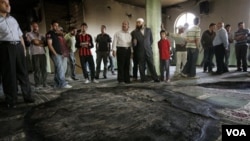 Warga Palestina di Tepi Barat memeriksa kerusakan akibat kebakaran di sebuah masjid di Al Mughayer, dekat Ramallah (7/6).