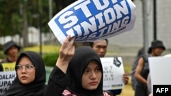 Beberapa aktivis perempuan membawa poster saat demo di Jakarta, 10 Desember 2019. (Foto: AFP)