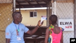 지난해 11월 라이베리아 몬로비아 외곽에서 보건요건이 에볼라 치료소에 들어서는 여성의 감염 여부를 검사하고 있다. (자료사진)