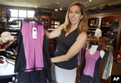 FILE - Kelly Daugherty, co-owner of Smashing Golf & Tennis, poses for a photo with her clothing line in the pro shop at Biltmore Country Club in North Barrington, Ill., Aug. 20, 2013.