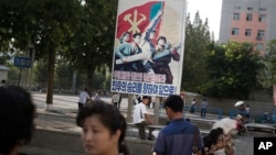 FILE - A man sits under a propaganda banner in Pyongyang, North Korea, Aug. 23, 2015. 