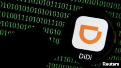 FILE - The app logo of Chinese ride-hailing giant Didi is seen through a magnifying glass on a computer screen showing binary digits in this illustration picture taken July 7, 2021. 