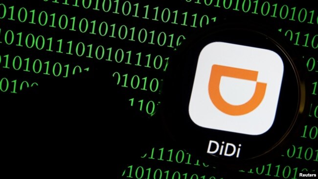 FILE - The app logo of Chinese ride-hailing giant Didi is seen through a magnifying glass on a computer screen showing binary digits in this illustration picture taken July 7, 2021.