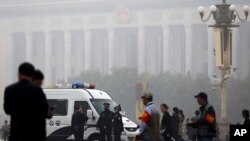 北京雾霾中，天安门广场上，人民大会堂前，有警车和警察（2014年10月20日）