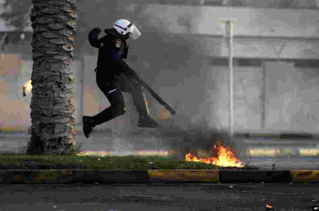 A riot policeman avoids petrol bombs thrown by Bahraini anti-government protesters, unseen, during clashes in Diraz, Bahrain. Clashes erupted after the funeral for Abdul Ghani al-Rayes, who relatives and activists say collapsed and died outside of a police station.