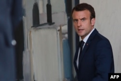 French President Emmanuel Macron (R) leaves after a meeting with the Senegalese President at the Elysee Palace in Paris, April 20, 2018.