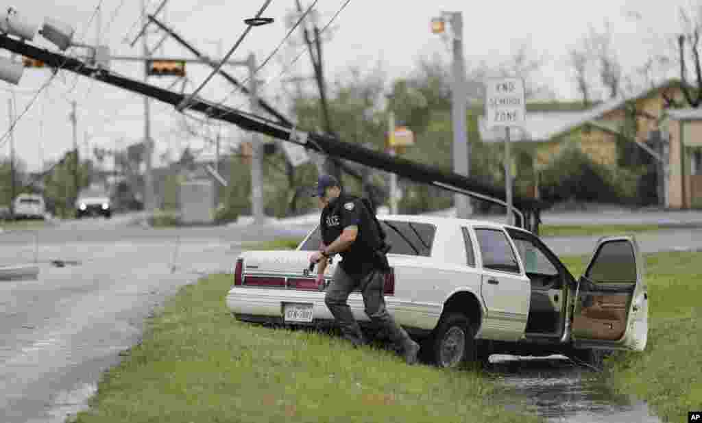 Поліцейський перевіряє покинутий автомобіль у місті Рокпорт у штаті Техас.26 серпня 2017 року.