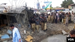 Aparat dan warga Pakistan mengerumuni TKP bom bunuh diri di Quetta, provinsi Baluchistan, Kamis (7/4).