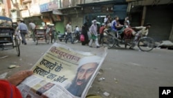 A man reads a local newspaper reporting the death of al-Qaida leader Osama bin Laden in the old quarters of Delhi, May 3, 2011