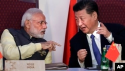 FILE - Indian Prime Minister Narendra Modi, left, talks with Chinese President Xi Jinping during the BRICS summit in Goa, India, Oct. 16, 2016. China and India may have ended a tense border standoff for now, but their longstanding rivalry raises questions.
