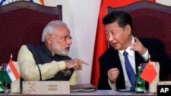 FILE - Indian Prime Minister Narendra Modi, left, talks with Chinese President Xi Jinping during the BRICS summit in Goa, India, Oct. 16, 2016. China and India may have ended a tense border standoff for now, but their longstanding rivalry raises questions