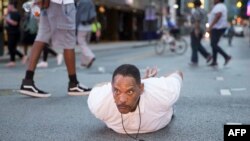 A man lays on the ground after yelling "Don't shoot me" at police during a rally in Dallas, Texas, July 7, 2016 to protest the recent shooting deaths by police of two African-Americans.