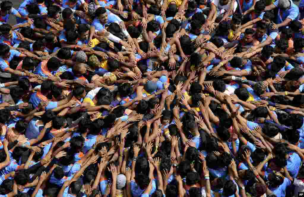 Indians form a human pyramid to break the &quot;Dahi Handi,&quot; an earthen pot filled with curd hanging above them, as part of celebrations to mark the Janmashtami festival in Mumbai.