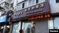 A boy looks up as he walks past the closed coffee shop owned by Canadian couple Kevin and Julia Dawn Garratt in Dandong, Liaoning province, August 5, 2014. 