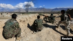 FILE - Afghan security forces take a position during a gunbattle with Taliban forces in Laghman province, Afghanistan, March 1, 2017.