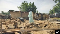 Rabiu Wada walks on the remains of his home, destroyed by flooding, in the village of Rimgim, near Dutse in northern Nigeria, 28 Sep 2010