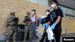 Tình nguyện viên dọn dẹp các cửa hàng bị cướp phá trong các cuộc biểu tình ở bang California, Mỹ, giữa bối cảnh đại dịch Covid-19.