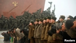North Korean soldiers salute as others bow to bronze statues (not pictured) of North Korea's late founder Kim Il-sung and late leader Kim Jong Il at Mansudae in Pyongyang, in this photo provided by Kyodo, February 16, 2015.