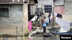 Une femme étale des habits sur un fil à côté du fleuve Niger à Bayelsa, Yenagoa, Nigeria, 8 octobre 2015.