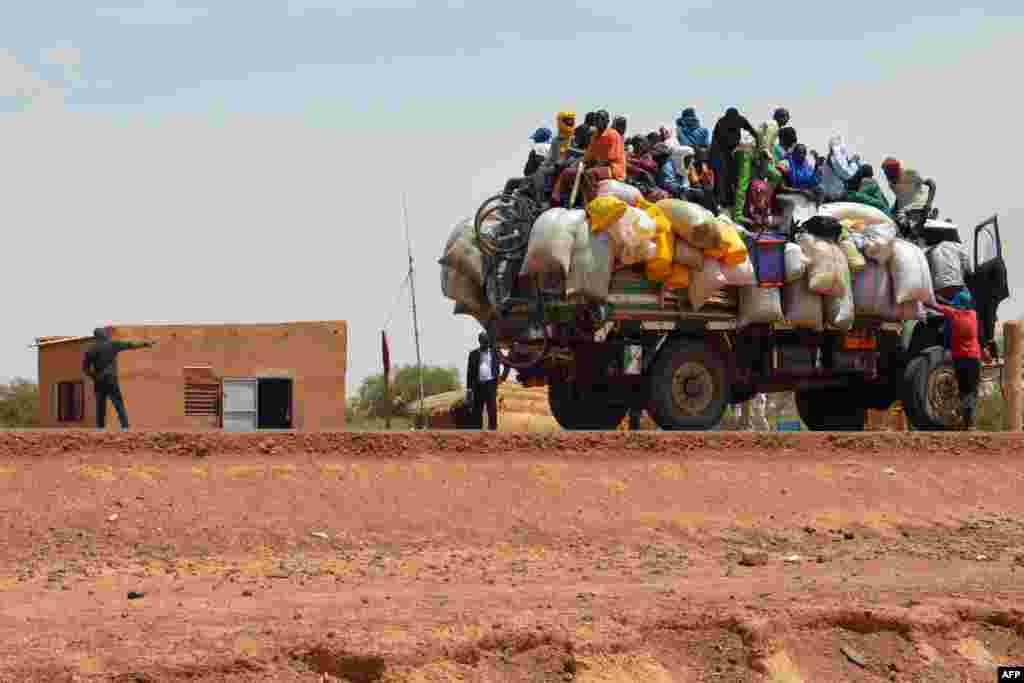 People ride in a loaded truck at the police checkpoint where two policemen were killed and four injured by armed men during an overnight attack in Niamey, Niger.