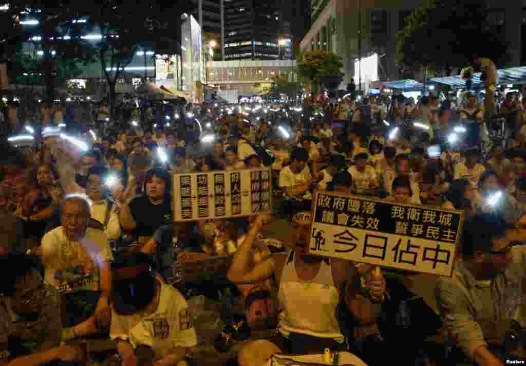 Protesters sing while waving mobile phones during an overnight sit-in at a street at Hong Kong's financial Central district July 1, 2014. The pro-democracy march on Tuesday, which organisers said attracted more than 510,000 people, and the subsequent sit-