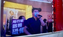 反送中运动两周年义卖活动回顾过去两年香港人的抗争历史，一张大型照片为前香港众志秘书长黄之锋去年7月参与民主派立法会35+初选拉票的情况。 (美国之音 汤惠芸拍摄)