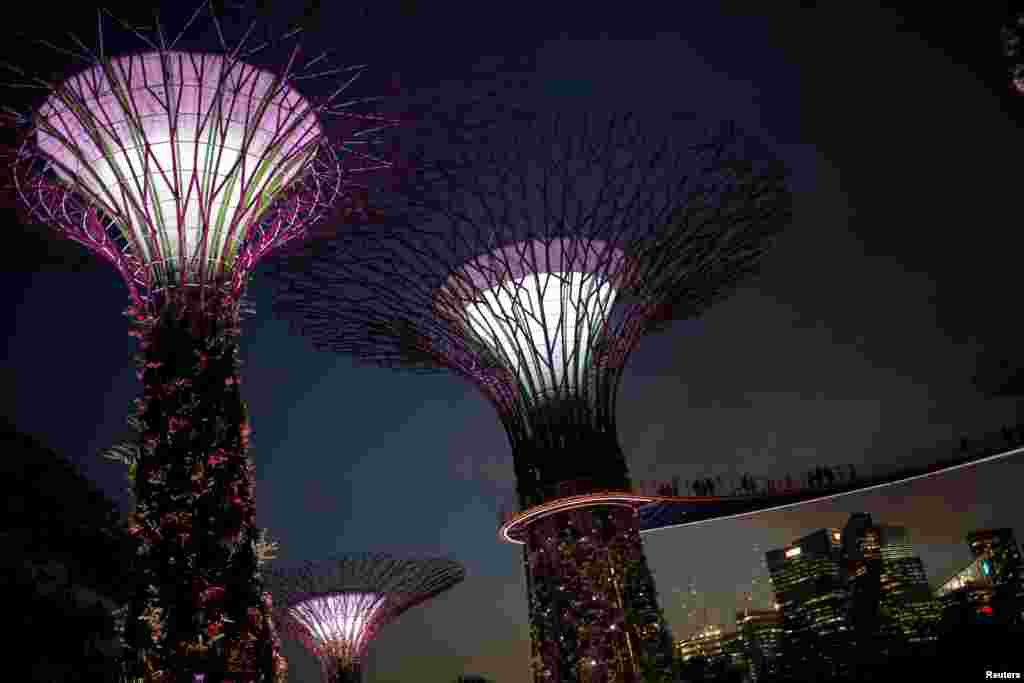 Orang-orang berjalan di atas jembatan pada taman di dekat Bay park di Singapura.