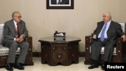 Menlu Suriah Walid al-Moalem (kanan) menemui utusan internasional Lakhdar Brahimi di Damaskus, Sabtu (20/10).