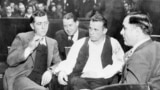 FILE - John Dillinger (C), a well-known gangster, is handcuffed and guarded in court awaiting his trial on Feb. 9, 1934. (AP PHOTO)