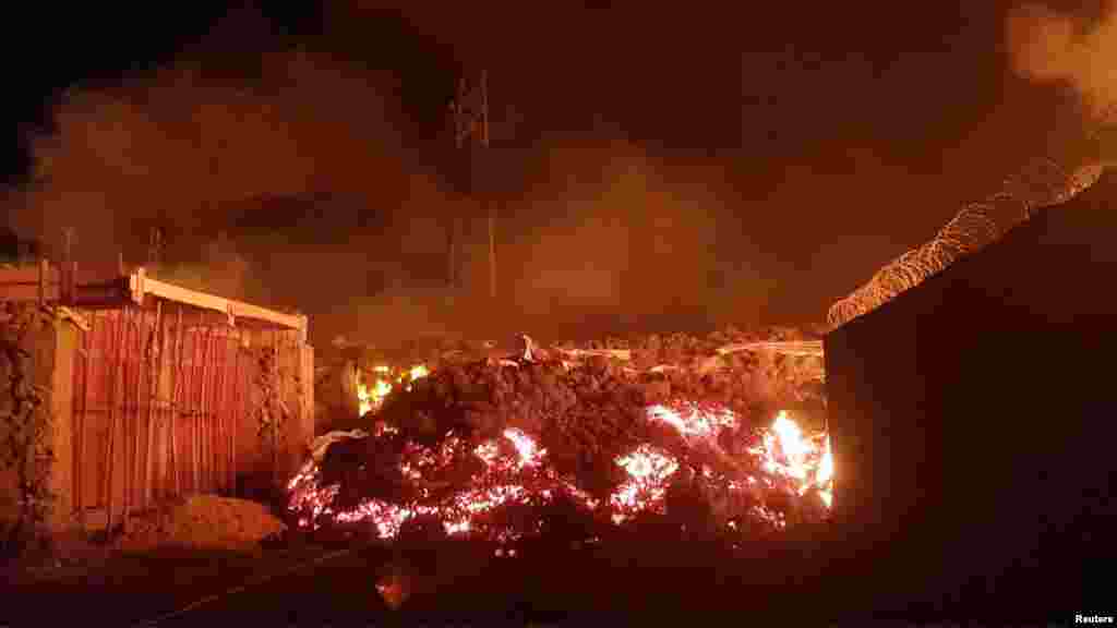 Flowing lava from the volcanic eruption of Mount Nyiragongo, May 22, 2021, is seen between buildings in Goma, Democratic Republic of Congo, in this still image from undated video obtained via social media. (Credit: Enoch David)