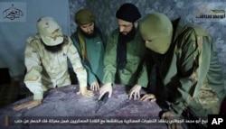 FILE - Abu Mohammed al-Golani, the leader of Fatah al-Sham Front, center, is seen in this undated picture posted by the group, discussing battlefield details with field commanders over a map.