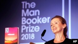 Writer Anna Burns smiles after she was presented with the Man Booker Prize for Fiction 2018 by Britain's Camilla, the Duchess of Cornwall, during the prize's 50th year at the Guildhall in London, Oct. 16, 2018. 