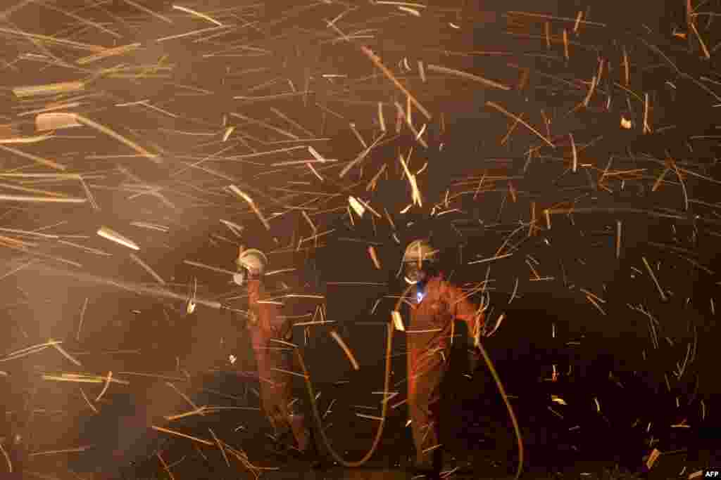 Members of Civil Defense and Forest Brigade of Riveira work at the site of a wildfire in Riveira, near La Coruna, Spain.