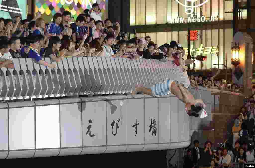 A Japanese soccer fan dives into Doton-bori river in Osaka to celebrate the country's qualification for the World Cup finals in Brazil, in this photo taken by Kyodo.