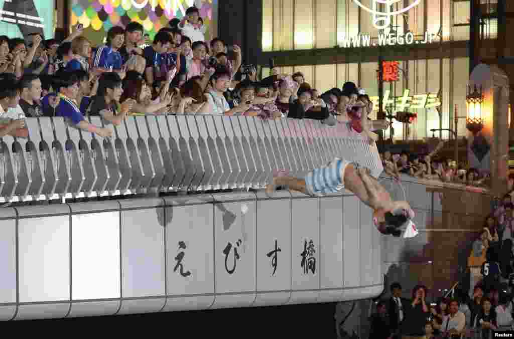 A Japanese soccer fan dives into Doton-bori river in Osaka to celebrate the country&#39;s qualification for the World Cup finals in Brazil, in this photo taken by Kyodo.