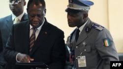 Ivory Coast's internationally recognized President Alassane Ouattara (L) uses an iPad prior to attending African Union talks in Addis Ababa, March 10, 2012. 