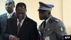 Ivory Coast's President Alassane Ouattara (L) uses an ipad prior to attending African Union talks in Addis Ababa, March 10, 2012.