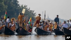 Komunitas dari etnis Entha memegang plakat dalam aksi protes menentang kudeta militer di Danau Inle, Taunggyi, Myanmar, Kamis, 11 Februari 2021.